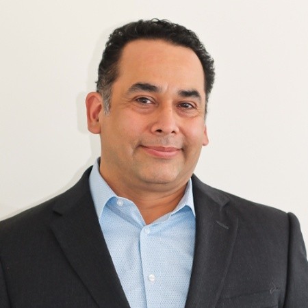 Professional portrait of Ray Fernandez smiling.